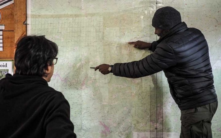 a person points at a map while another looks on during an outward bound gap year course